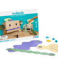 Makedo Deco-Props Biobbies toy set with its retail box, showing cardboard box props, colorful wavy adhesive pieces in green, purple, and yellow, and small blue and yellow plastic connectors on a white background.