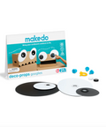 Makedo Deco Props Googlies toy set with its retail box, showing cardboard monster eyes, googly eyes, black and white circular discs, and small blue and yellow accessories on a white background.