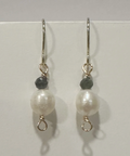 Pair of pearl earrings with black beads on a white background