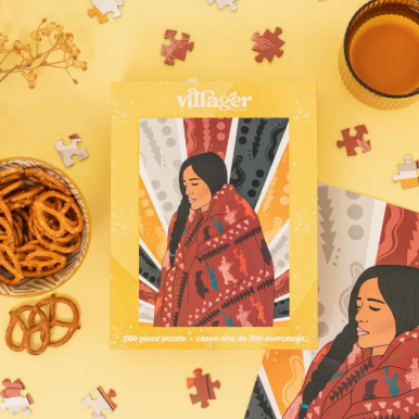 Village puzzle packaging with a woman in a red patterned shawl on a yellow background.