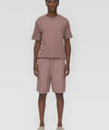 Man wearing a brown t-shirt and shorts set on a white background