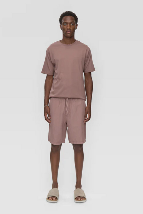 Man wearing a brown t-shirt and shorts set on a white background