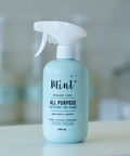 All-purpose cleaner bottle labeled 'Mint' on a blurred background