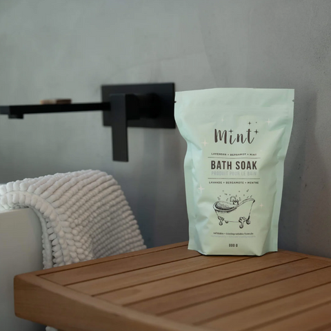 Bag of Mint Bath Soak on a wooden surface with a towel in the background