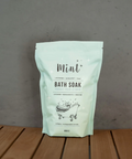 Mint bath soak package on a wooden surface with a gray background