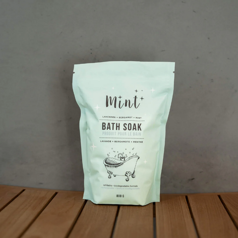 Mint bath soak package on a wooden surface with a gray background
