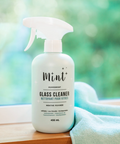 Glass cleaner bottle with 'Mint' branding on a blurred natural background