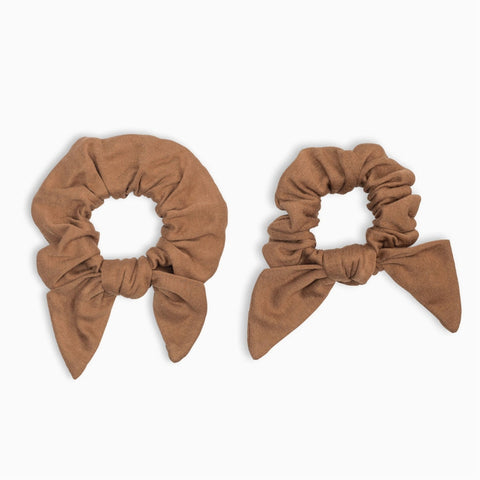 Two brown scrunchies with bow details on a white background