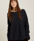 Person wearing a black sweater against a plain background