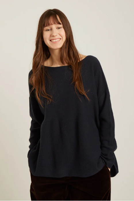 Person wearing a black sweater against a plain background
