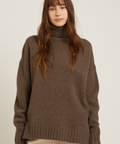 Woman wearing a brown sweater on a plain background