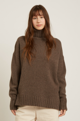 Woman wearing a brown sweater on a plain background