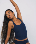 Woman in navy blue athletic outfit posing against a plain background