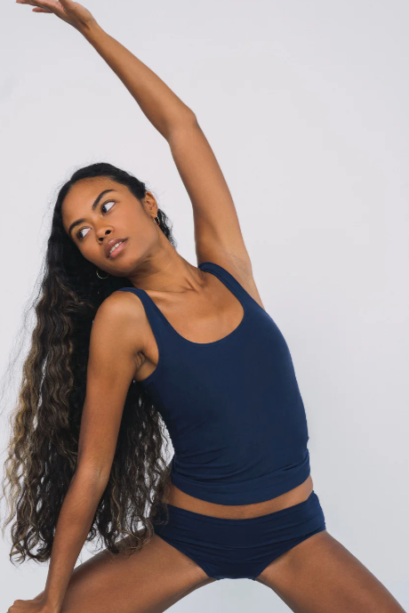 Woman in navy blue athletic outfit posing against a plain background