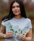 Woman holding plant-themed cards outdoors