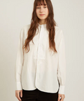 Woman wearing a white blouse against a plain background