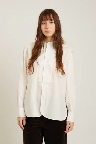 Woman wearing a white blouse against a plain background