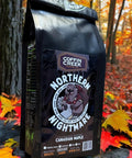 Coffin Creek Coffee bag labeled 'Northern Nightmare' in a forest setting with autumn leaves.