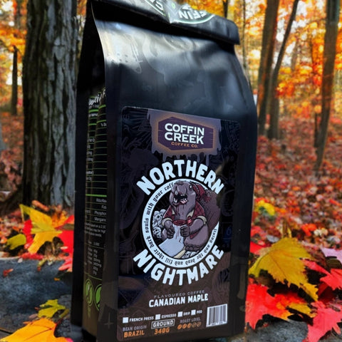 Coffin Creek Coffee bag labeled 'Northern Nightmare' in a forest setting with autumn leaves.