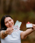 Woman holding a product with a maple leaf design outdoors