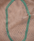 Turquoise beaded necklace on a beige fabric background
