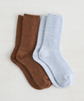 Two pairs of socks, one brown and one light blue, on a light gray background.
