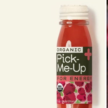 Bottle of Organic Pick-Me-Up with red liquid and white cap on a light beige background