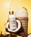 Piá Colada bottle with a coconut, pineapple, and a drink on a yellow background