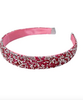 A pink glittery headband with rhinestone embellishments, shown against a plain white background.