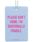 A rectangular light blue greeting card with a white hanging string, featuring bold pink text that reads 'PLEASE DON'T HONK. I'M EMOTIONALLY FRAGILE.