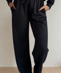 Person wearing black pants against a plain background