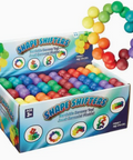 A retail display box of Shape Shifters sensory toy juetel sensory balls, filled with multicolored plastic balls and shown with a rainbow arch arrangement of the same balls on a white background.