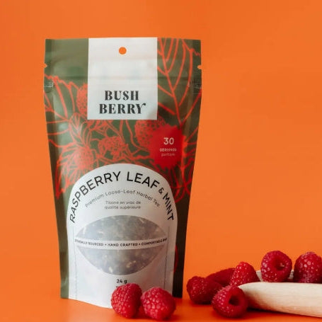 Packaging of Bush Berry Raspberry Leaf & Mint tea with raspberries on an orange background