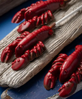 Red lobster-shaped candies on a wooden surface with a blue background