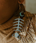 Closeup of model wearing the black acrylic Medium Salmon Ghost earring from Copper Canoe Woman.