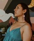 Model wears Matte Coral Medium Salmon Ghost Earrings from Copper Canoe Woman.