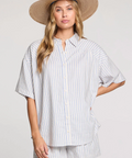 Woman wearing a striped shirt and wide-brimmed hat on a plain background