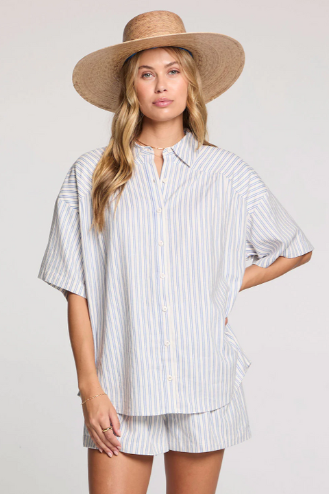 Woman wearing a striped shirt and wide-brimmed hat on a plain background
