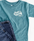 Blue t-shirt with 'Hide and Seek Club' text and jeans on a white background