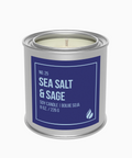 Candle in a tin labeled 'Sea Salt & Sage' on a white background
