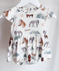 Baby dress with animal print on a hanger against a white background