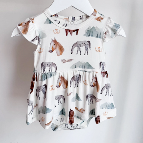 Baby dress with animal print on a hanger against a white background