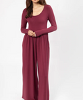 Woman wearing a burgundy long-sleeve dress on a white background