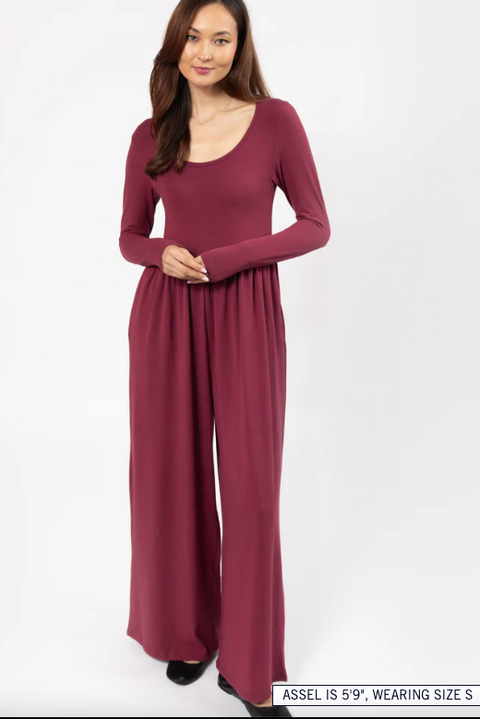 Woman wearing a burgundy long-sleeve dress on a white background
