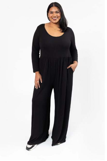 Woman wearing a black jumpsuit on a white background