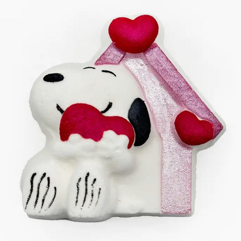 Snoopy character holding a red heart with a pink house-shaped hat on a white background