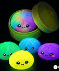 Colorful glowing balls with cartoon faces in a green container on a black background