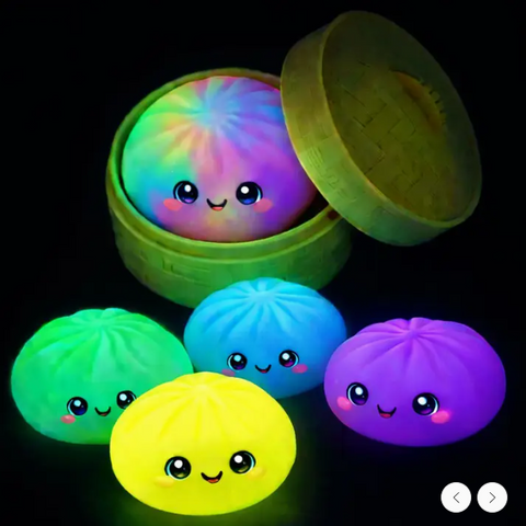 Colorful glowing balls with cartoon faces in a green container on a black background