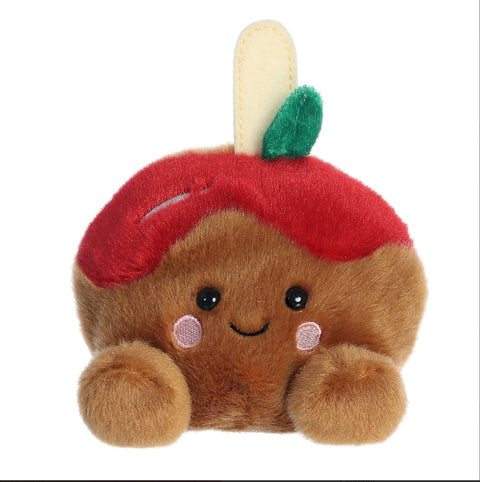 Plush toy resembling a brown bear with a red apple on its head against a white background