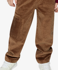 A close-up of a child wearing brown corduroy pants, a burgundy sweater, and white sneakers against a plain white background.